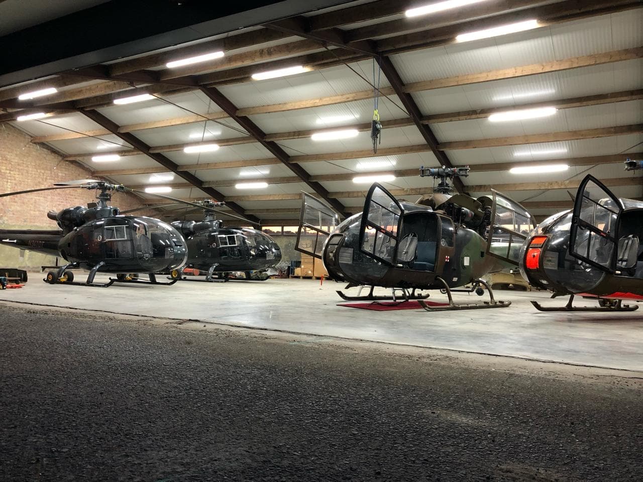 A row of Gazelle helicopters in the DE TRACY BV hangar